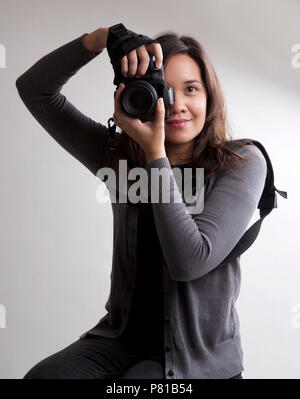 Female photographer posing with a camera Stock Photo