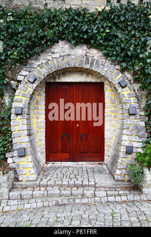 Horseshoe shaped doorway in stone wall, Vila Praia de Ancora, Minho Province, northern Portugal Stock Photo