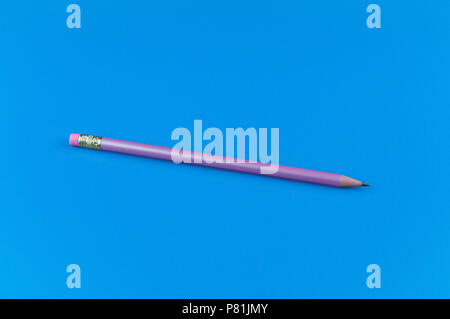 One purple pencil on a blue solid background. Stock Photo