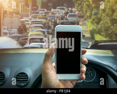 man using a smartphone while driving a car Stock Photo