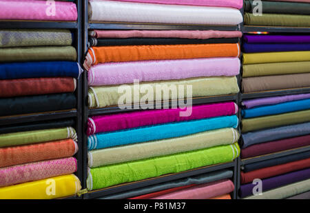 Roll in a colorful satin fabric store. Satin with a satin patterned on the popular Chinese garment. Stock Photo
