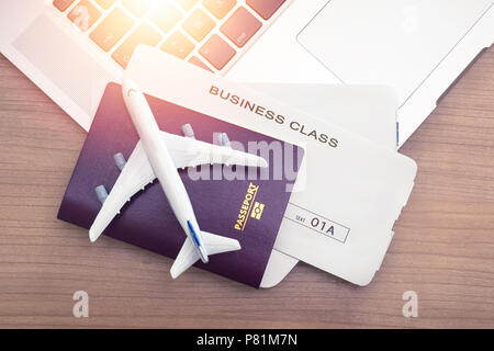 Two tickets are on the table with a laptop. buying online ticket booking for travel concept Stock Photo