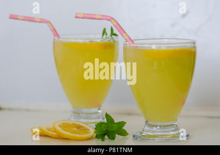 Refreshing drinks for summer, cold sweet and sour lemonade juice  in the glasses garnished with sliced fresh lemons Stock Photo