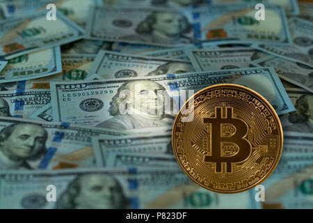Bitcoin overlaid against 100 dollar US bills or notes Stock Photo