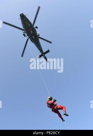 BALTIC SEA (May 24, 2016) A Lithuanian search and rescue technician descends from a Lithuanian helicopter to secure a Royal Canadian Navy diving casualty during a medical evacuation drill in the Baltic Sea while in support of Open Spirit 2016, May 24. Open Spirit is an annual multinational naval mine clearance and explosive ordnance disposal operation held between NATO and Partnership for Peace countries. Stock Photo