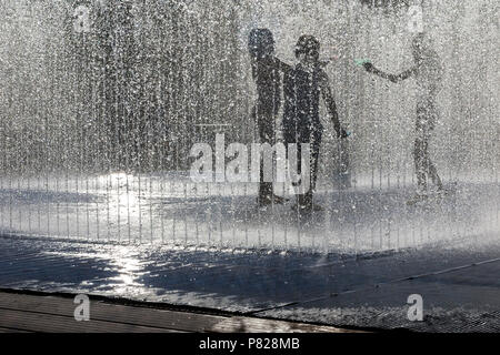 Children play in the fountains on London's Southbank Centre on a hot summer's day as England enjoys a heatwave Stock Photo