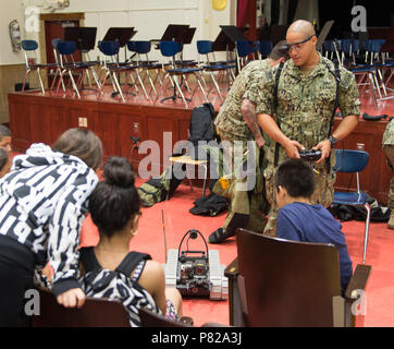 BROOKLYN, N.Y. (May 27, 2016) — Explosive Ordnance Disposal Technician 3rd Class Abraham Ruiz, assigned to Explosive Ordnance Disposal Mobile Unit 12, operates a  PackBot transportable robotics system for students during a Science, Technology, Engineering, and Mathematics (STEM) event at David A. Boody Intermediate School in Brooklyn as part of 2016 Fleet Week New York (FWNY), May 27. FWNY, now in its 28th year, is the city's time-honored celebration of the sea series. It is an unparalleled opportunity for the citizens of New York and the surrounding tri-state area to meet Sailors, Marines and Stock Photo