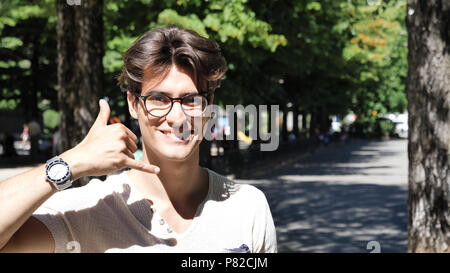 Young man doing call me sign with hand Stock Photo