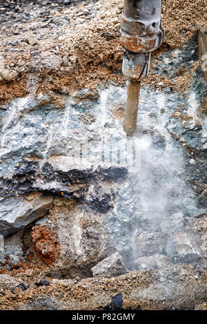 Close up of jackhammer - worker man using a jackhammer to drill into concrete. Close up of jackhammer - destroying concrete wall Stock Photo