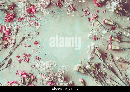 Summer flowers frame composition made with various colorful pastel garden flowers, petals and leaves on desktop background, top view. Retro styled Stock Photo