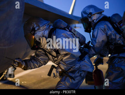 Sailors from Crash and Salvage access the control panel of an F/A-18C ...