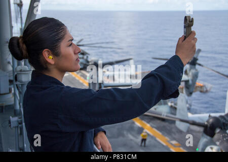 HONG KONG  (Oct. 4, 2016) Petty Officer 3rd Class Luisa Caceres, from Albany, N.Y., reads a Kestrel instrument to gather weather observations aboard amphibious assault ship USS Bonhomme Richard (LHD 6). Bonhomme Richard, flagship of the Bonhomme Richard Expeditionary Strike Group, is operating in the South China Sea in support of security and stability in the Indo-Asia Pacific region. Stock Photo