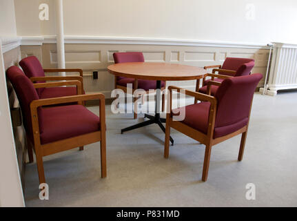 Five empty chairs around a table in a school or office workspace Stock Photo