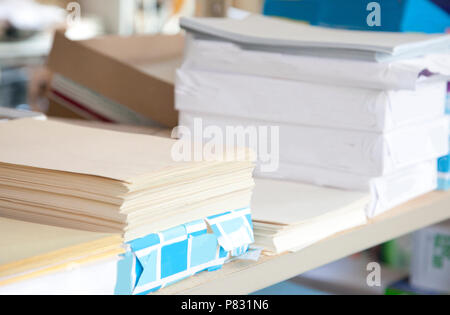 Office supplies stacked with reams of cream colored paper Stock Photo