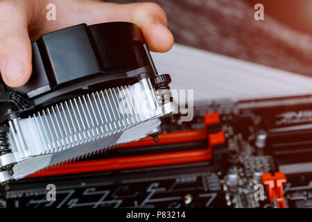 Technician hands installing CPU cooler fan on a computer pc motherboard Stock Photo