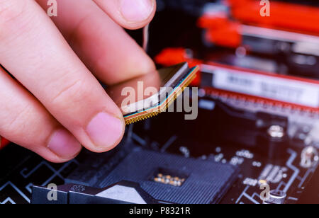 Computer technician installing CPU into motherboard. Close up. installed in PC motherboard. Stock Photo