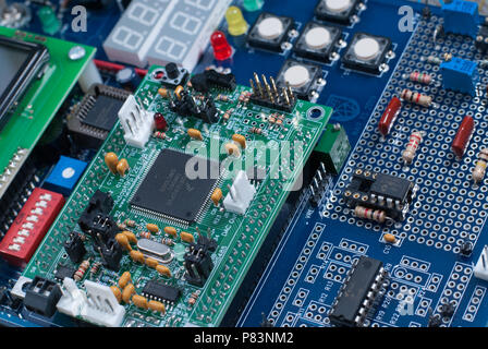 Close up of electronic parts in a microcontroller including diodes, transistors, resistors, capacitors, and processors. Stock Photo
