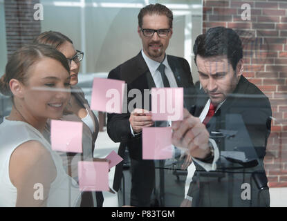 group of business people reading business notes on a glass Board Stock Photo