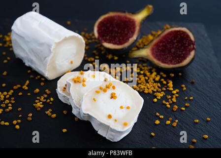 Fresh goat cheese with pollen and figs on black bacground, Stock Photo