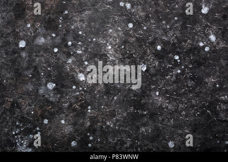 Grunge texture of old plaster wall with cracks and white spots. Dark gray abstract rough background. Stock Photo