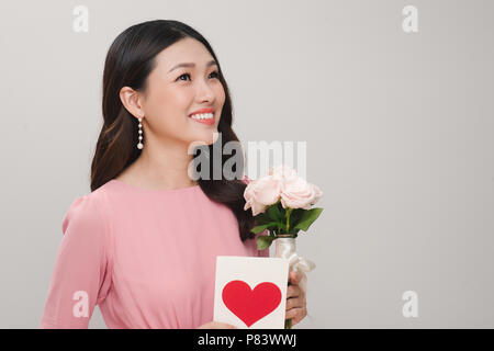 Young beautiful smiling woman holding bouquet of beautiful roses flowers, postcard isolated on white background. St. Valentines Day or International W Stock Photo