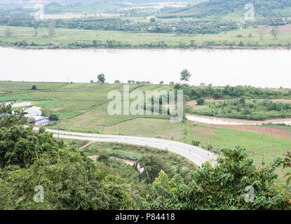 Curve asphalt road along the large river which through the countryside farm.northern of Thailand. Stock Photo