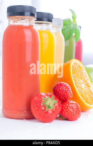 Many different fruits and berries and juices in plastic bottles. Watermelon, banana, applcsin, blueberries, strawberries, basil on a white background. Vitamin and healthy food. Detox. Copy space Stock Photo