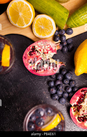 Fruits, berried and vegetables next to glasses with detox water Stock Photo