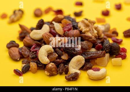 Close up of mix of dried fruits and nuts on a yellow background Stock Photo