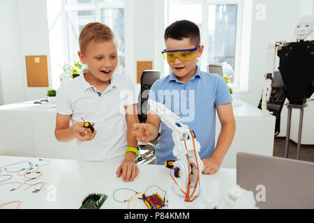 Joyful happy boys working on their science project Stock Photo