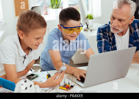 Positive nice boy sitting in front of the laptop Stock Photo