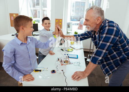 Happy aged man giving high five Stock Photo