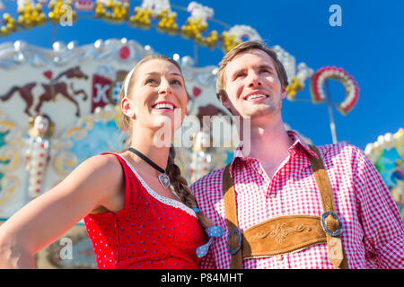 Couple visiting Bavarian fair having fun Stock Photo
