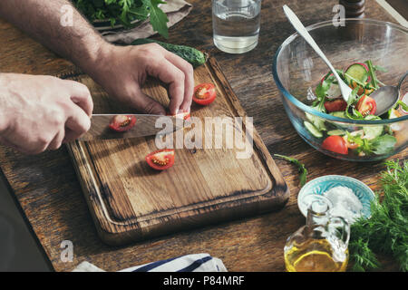 Healthy food concept. Man preparing breakfast from salad in home kitchen Stock Photo