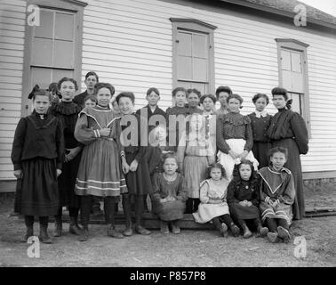 One-room schoolhouse students pose for a class photo on the American Great Plains, ca. 1905. Stock Photo