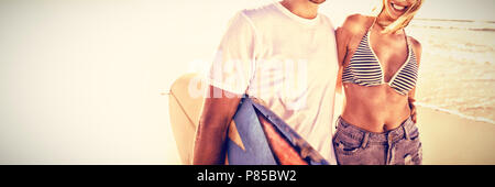Portrait of happy young couple wearing sunglasses at beach Stock Photo