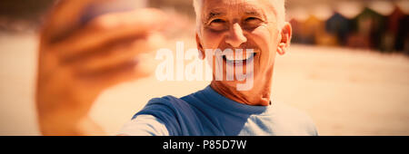 Happy senior man taking selfie at beach Stock Photo
