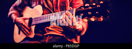 Mid-section of man playing guitar Stock Photo