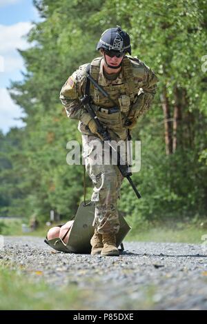 U.S. Army 1st Lt. Robert L. Martin assigned to 1st Battalion, 4th Infantry Regiment, 7th Army Training Command (7th ATC) pulls a simulated casualty on a sked litter during the stress shoot lane as part of the 7th ATC Best Warrior Competition, Grafenwoehr Training Area, Germany, June 20, 2018, June 20, 2018. The three-day event ends June 21 with the announcement of the 7th ATC Officer, Noncommissioned Officer and Soldier of the Year. The winners will move on to compete in the U.S. Army Europe Best Warrior Competition. (U.S. Army photo by Gertrud Zach). ()