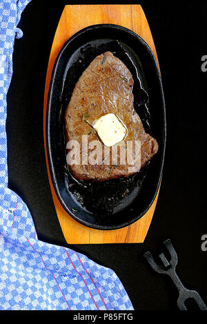 Butter Melting on Beef Steak served on Cast Iron Stock Photo