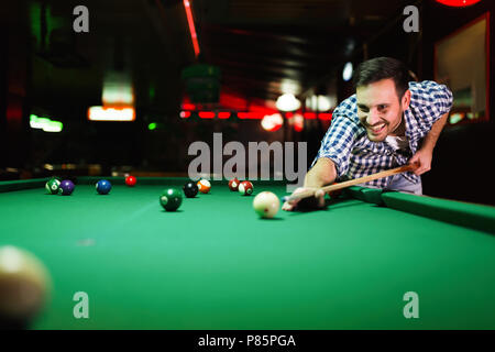 Young attractive man playing pool in bar Stock Photo
