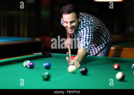 Young attractive man playing pool in bar Stock Photo