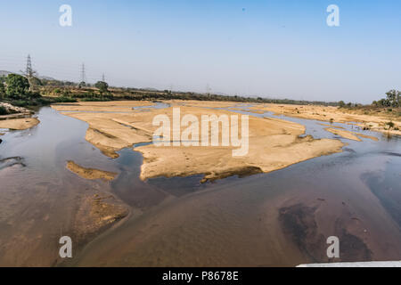 Indian river with clean water in sandy bed  with power grid cable laying background. Stock Photo