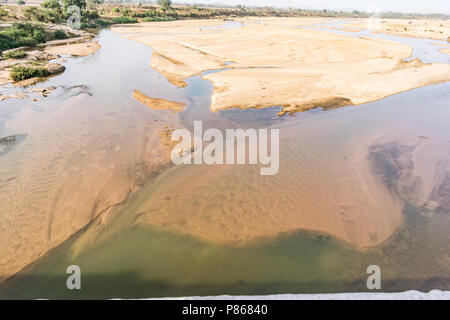 Indian river with clean water in sandy bed  with power grid cable laying background. Stock Photo