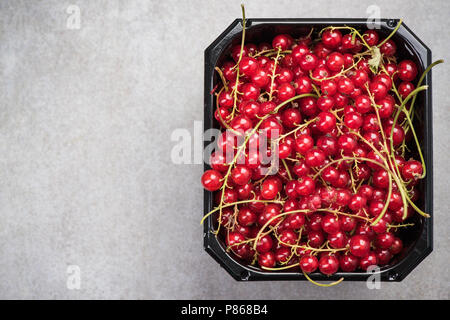 Market fresh redcurrant in plastic container. Copy space, overhead image. Stock Photo