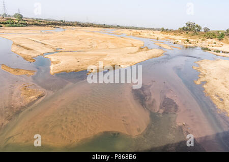Indian river with clean water in sandy bed  with power grid cable laying background. Stock Photo