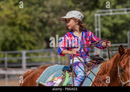 Attractivr, young girl, action shot as she looks back while riding on a trail ride adventure. Good dramatic shot. Stock Photo