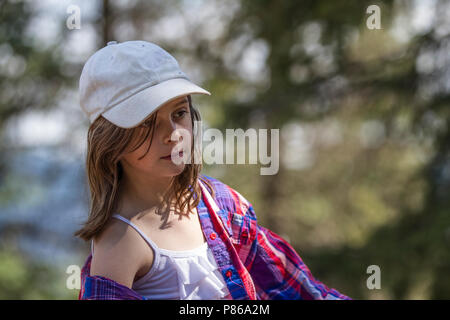 Attractivr, young girl, sitting in the saddle, on a trail ride adventure, deep in thought. Stock Photo