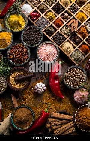 A selection of various colorful spices on a wooden table in bowls Stock Photo