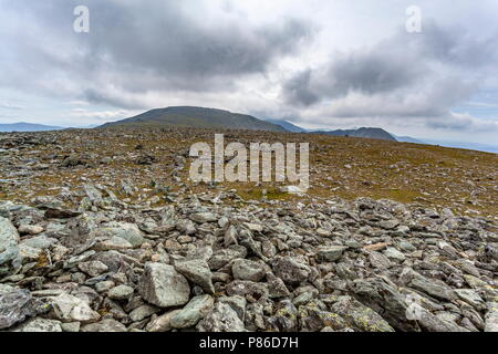 The summits of Carnedd Llewelyn and Yr Elen viewed from the rock strewn summit of Foel Grach Stock Photo